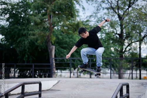 Young Asian Man Jumping with Skateboard at Outdoor Skate Park Extreme Sport