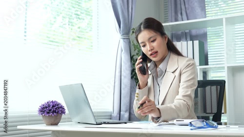 Young businesswoman reviewing financial documents and reports at a modern office desk, analyzing data and managing paperwork with focus and professionalism.