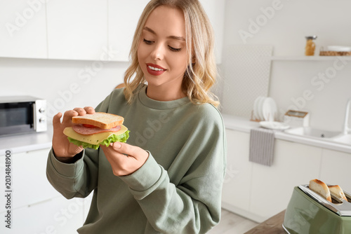 Young beautiful woman eatin...