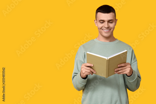 Handsome young man reading ...