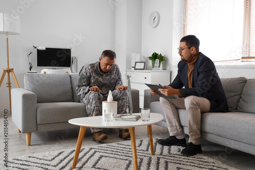 Male psychologist working with mature soldier in office