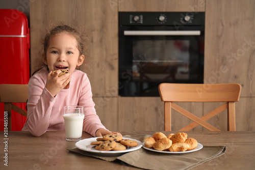 Little girl eating cookie w...