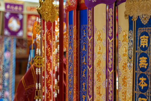 Quadro su tela Close up of embroidered prayer flag hanging inside Taoist temple