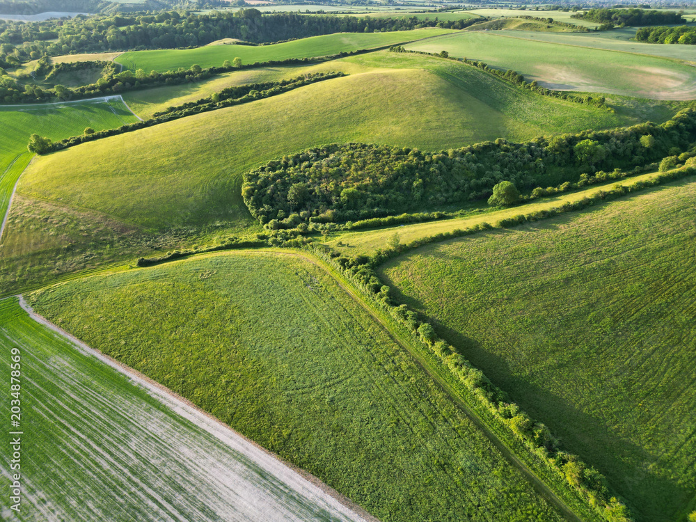 Obraz premium High Angle View of British Countryside and Landscape of Bedfordshire England UK. Drone Camera Footage Was Captured Medium High Altitude During Bright Sunny Day With Blue Sky and Hot Summer Day Over UK