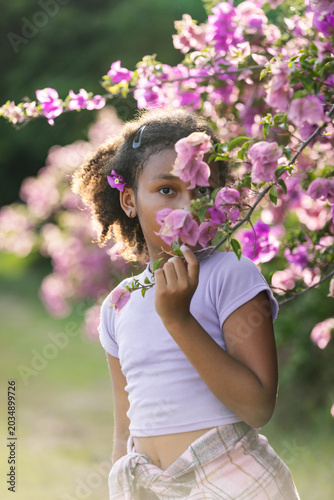 Young Girl Portrait Among Pink Bougainvillea Flowers in Tropical Garden