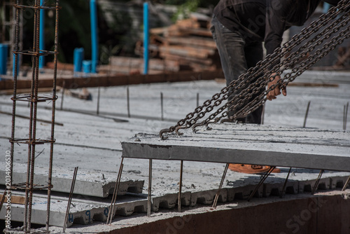 Crane loader for lifting bundles of precast concrete slabs.
