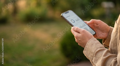 Person analyzing business dashboard on smartphone outdoors.