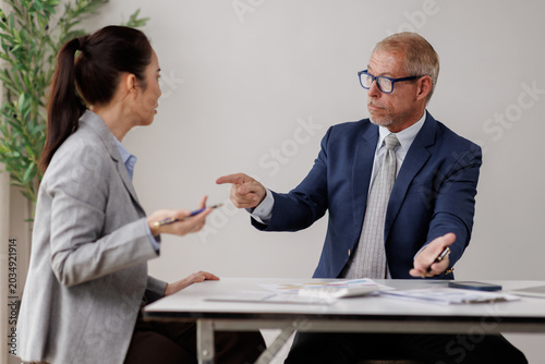 Εκτύπωση καμβά Senior male manager pointing an accusatory finger at a young businesswoman, crea