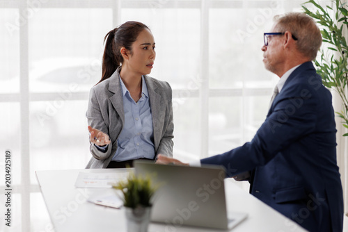 Tableau sur toile Businesswoman in a tense office meeting gesturing with an open hand while speaki