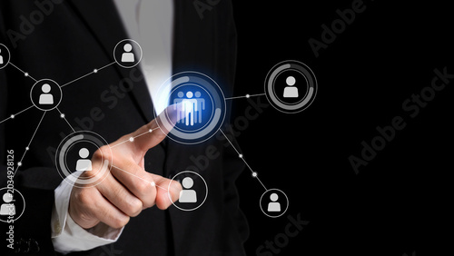 Networking the Future: A professional's finger interacts with a glowing digital interface, connecting virtual figures in a network, symbolizing connections and global reach.