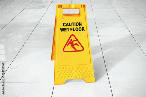 Yellow caution sign warning of a wet and slippery floor