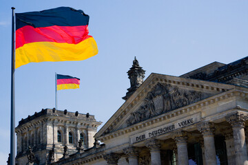 Germany, Berlin, view to upper part of Reichstag building with two German flags