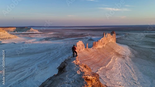 a man stands and watches the sunset in Bozzhyra is a tract in the western part of the Ustyurt Plateau on the Mangyshlak Peninsula in the Mangystau Region of Kazakhstan