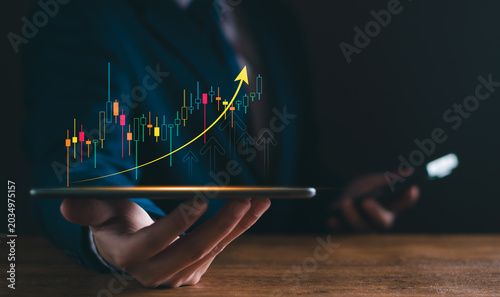 Business and investment concept. holding a digital tablet glowing financial chart with rising growth arrow. stock market analysis, asset management, capital gains, and successful wealth strategy.