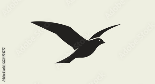 Fotografía Black silhouette of a bird in flight against a neutral background, symbolizing freedom and nature