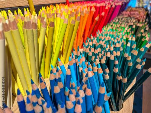 Many brightly colored sharpened pencils standing in containers, creating a beautiful spectrum and rainbow effect, perfect for art, creativity, and education concepts - stock photo