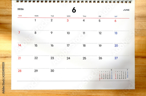 2026 calendar, June 2026 desk calendar on a wooden desk, 2026 New Year's plans.