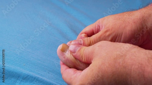 Cinematic close-up of male hands performing a relaxing foot massage after a hard day's work. Shooting in soft natural light.