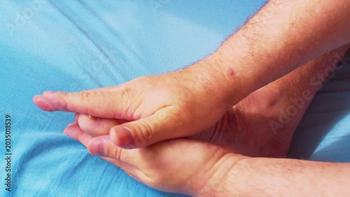 Foot Self-Massage for Tension and Fatigue Relief.A detailed close-up shot of a man's hands massaging his tired foot after a demanding work day. Filmed in soft, natural light