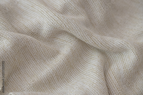 Beige cotton fabric with subtle metallic threads, creating a creative texture background with soft gold sheen and copy space.