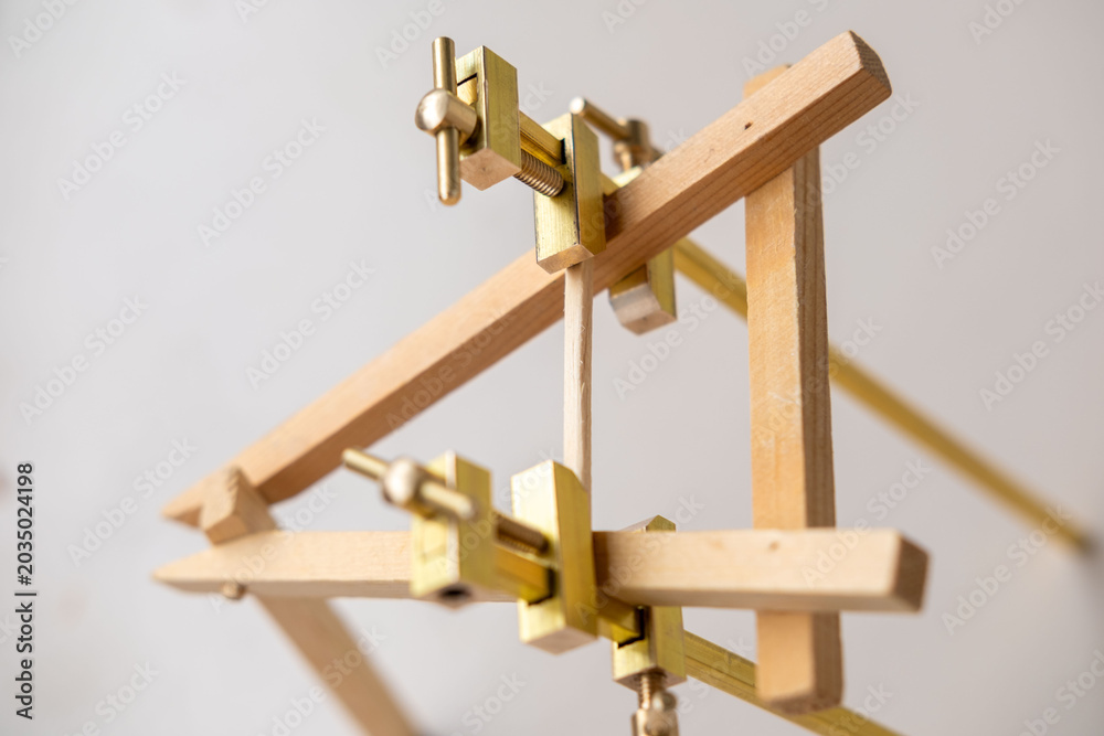 Fototapeta premium miniature wooden easel brass hardware adjustment screws crafting tools art supply manufacturing workshop precision woodworking handmade model display stand creative hobby project, dollhouse designers