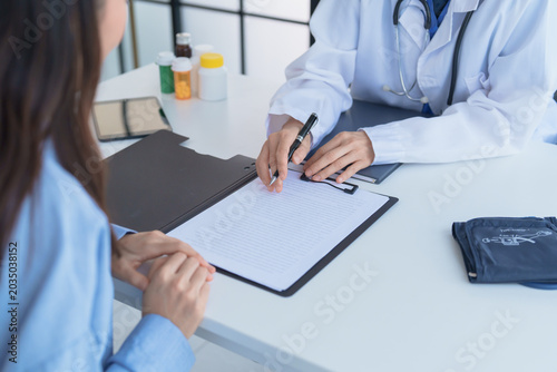 Fotografie Doctor explaining treatment plan and obtaining informed consent while patient signing consent form in hospital