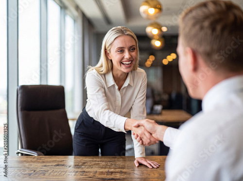 Fotografie Happy businesswoman shaking hands with a colleague after a successful negotiation or job interview