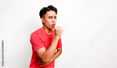Konstfotografi Sick young southeast asian man coughing and holding stomach feeling unwell isola
