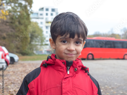 Cute Little Boy in Red Winter Jacket Smirking and Looking at Camera