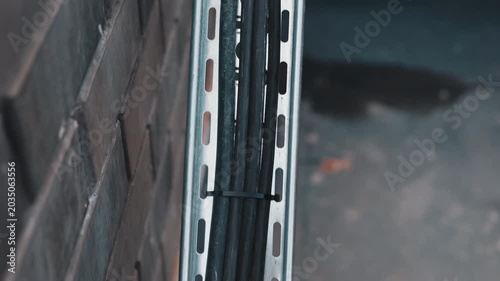 Electrical cables mounted in metal cable tray on building wall