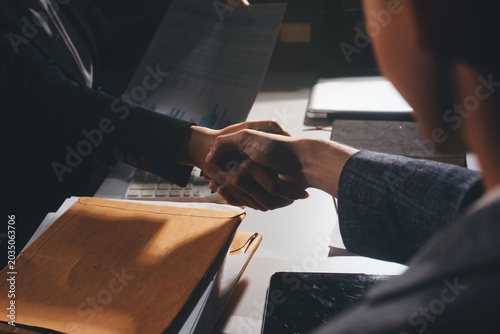 Professional photo of a person's hands reviewing a contract or legal document on a desk, for concepts of business, finance, and legal affairs