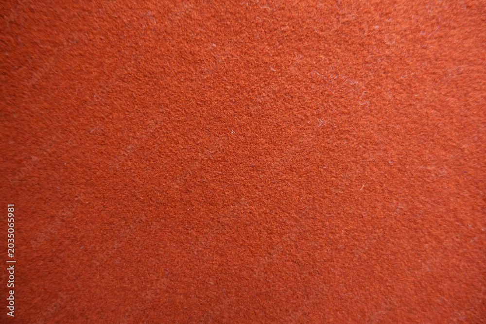 Fototapeta premium Texture of simple reddish orange felt fabric