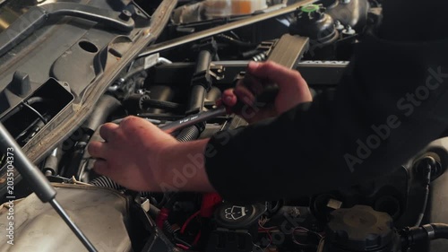 Odijk, Netherlands, May 2, 2026. Car mechanic uses torque wrench to loosen ignition coils . Close up of hands