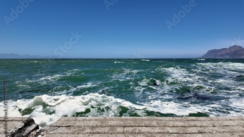 Rough sea waves crashing on pier in Kalk Bay, South Africa. 