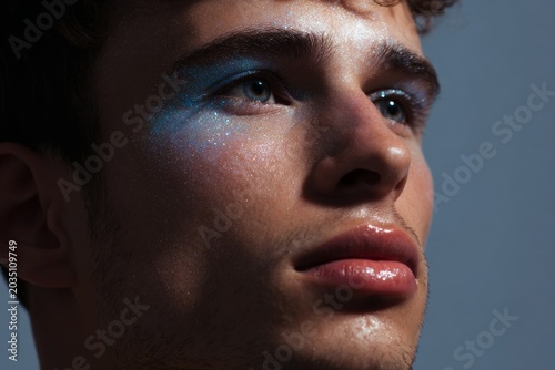 Trend male cropped close up with sky blue glowing eye and nose highlight for makeup editorial and beauty banner