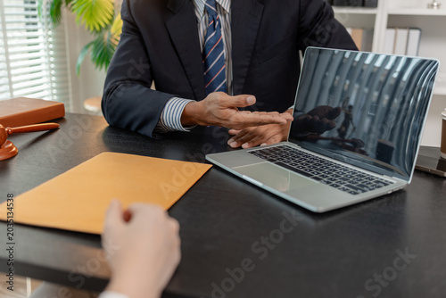 Professional legal consultation meeting between lawyer and client in office, discussing case documents, legal advice, contract review, negotiation, and justice services in a corporate setting.