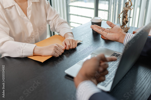 Professional legal consultation meeting between lawyer and client in office, discussing case documents, legal advice, contract review, negotiation, and justice services in a corporate setting.