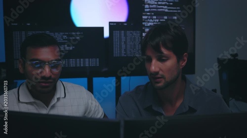 Software Developers Discussing AI Code On Computers In Tech Office Setting