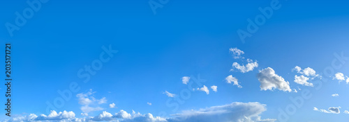 A gentle flight of cascading clouds on the horizon. Bright blue sky with cirrus clouds in high distance, horizontal smoke altitude banner. Weather, spring and summer, peace, hope and purity concept