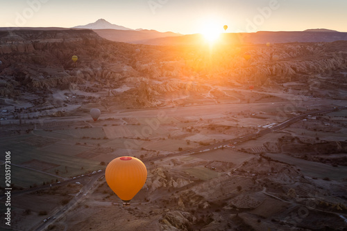 Colorful hot air balloons over the hills at sunrise in Cappadocia, Turkey.