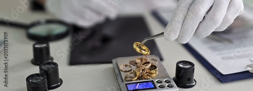 Slika na platnu A person wearing gloves measures various gold jewelry pieces on a digital scale