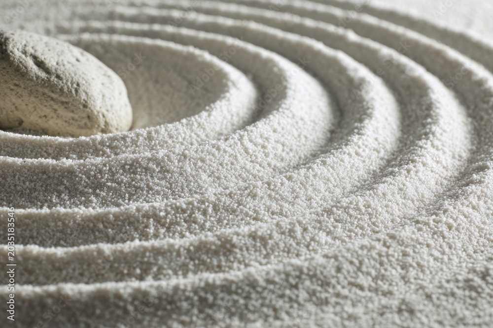 Naklejka premium Zen Garden Raked Sand with Stone Close-up.