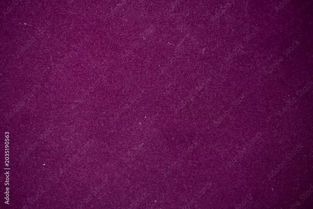 Fototapeta premium Purple velvet fabric texture creating a soft, luxurious background, showing rich, deep magenta and royal violet hues