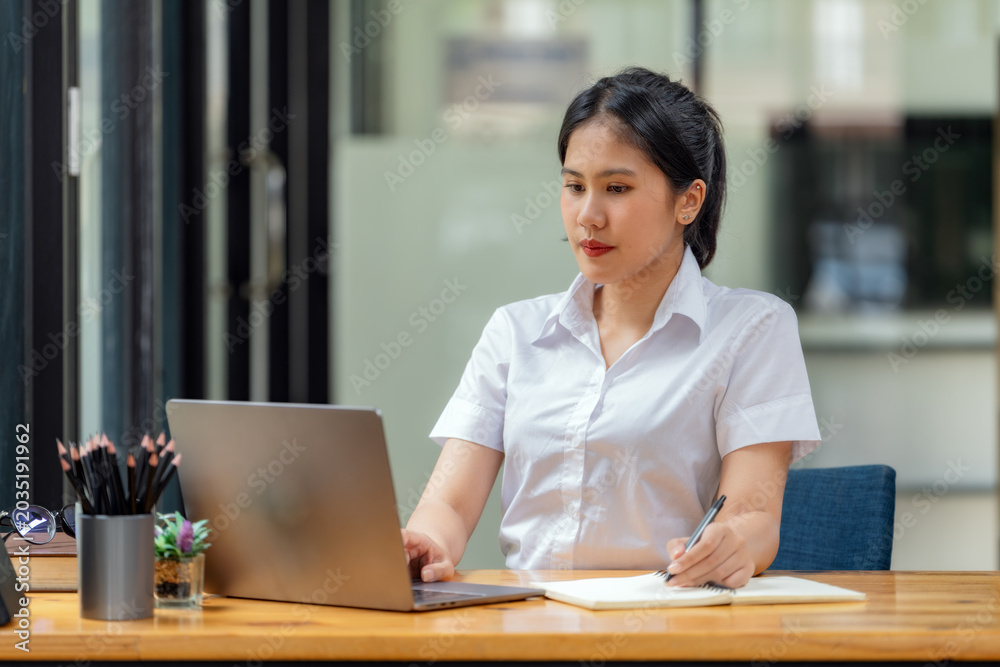Φωτογραφία Concentrated Asian businesswoman typing on laptop computer at office desk