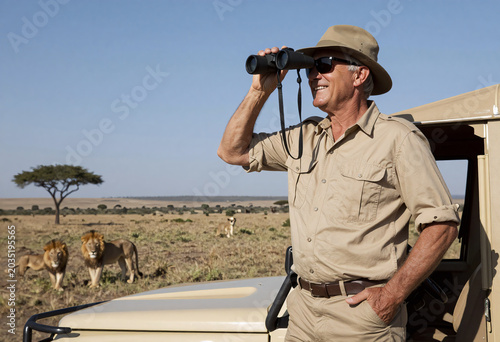 Safari guide with binoculars on Land Rover in Kenya