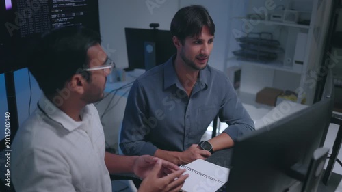 Software Developers Discussing AI Code On Computers In Tech Office Setting