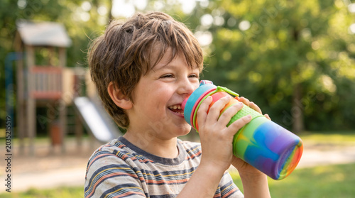 Young Boy Staying Hydrated with Reusable Water Bottle
