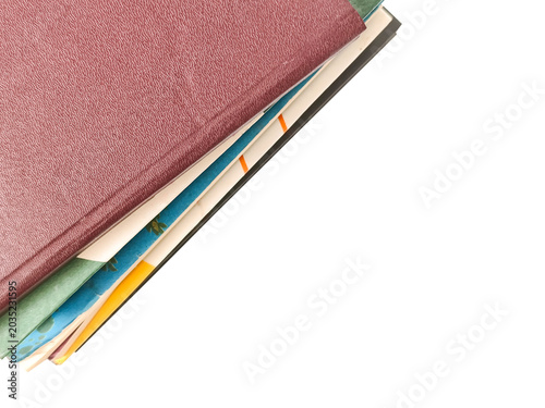 The edge of a stack of books with colorful covers on an isolated white background.