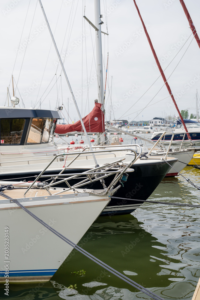 Obraz premium Luxury sailboats moored in modern marina harbor with calm water and nautical equipment