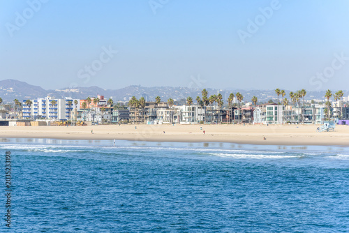 View of Venice Beach lined with palm trees and residential buildings on a sunny autumn day. CA, USA.